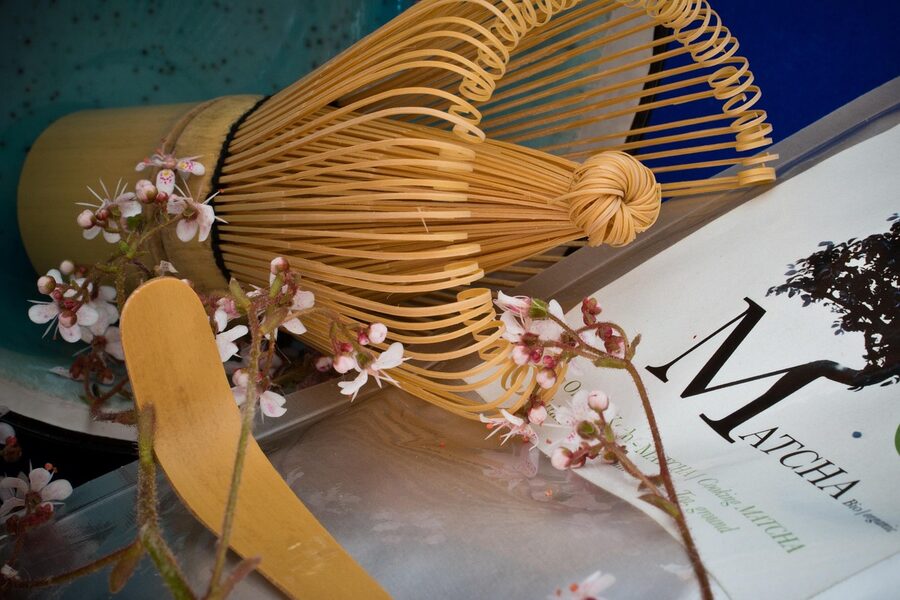 Matcha tea ceremony accessories laid out on wooden table