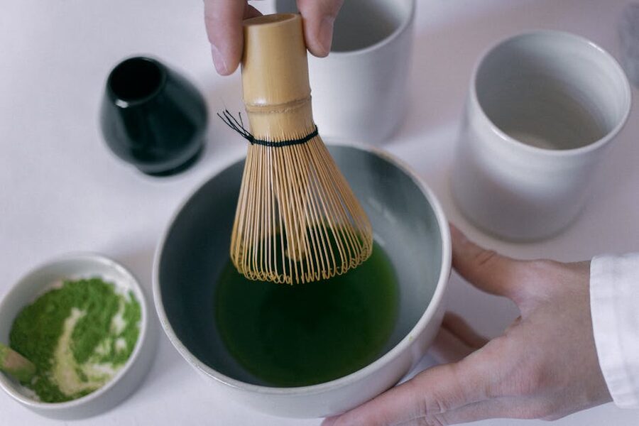 Whisking matcha in a ceramic bowl during Osaka class