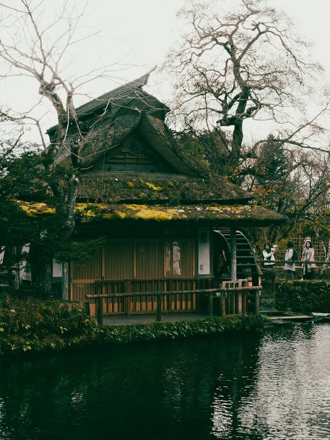 Elegant thatched house with waterwheel in Oshino, showcasing traditional Japan