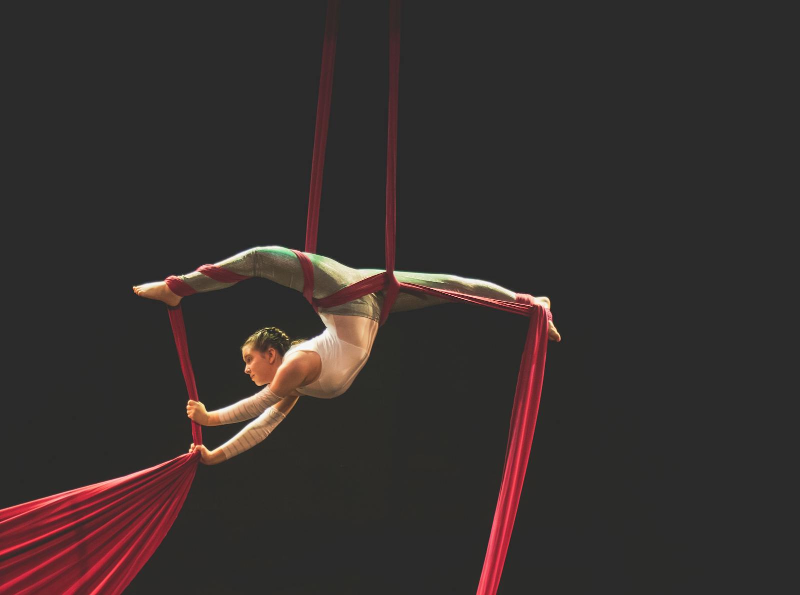 Aerial silk performer on red silks