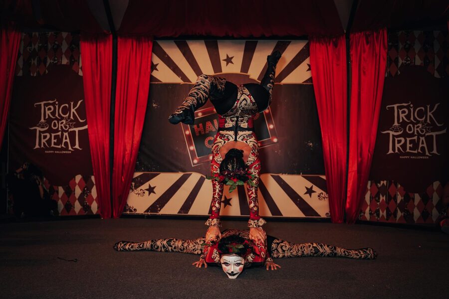 Two circus acrobats in colorful costumes on stage