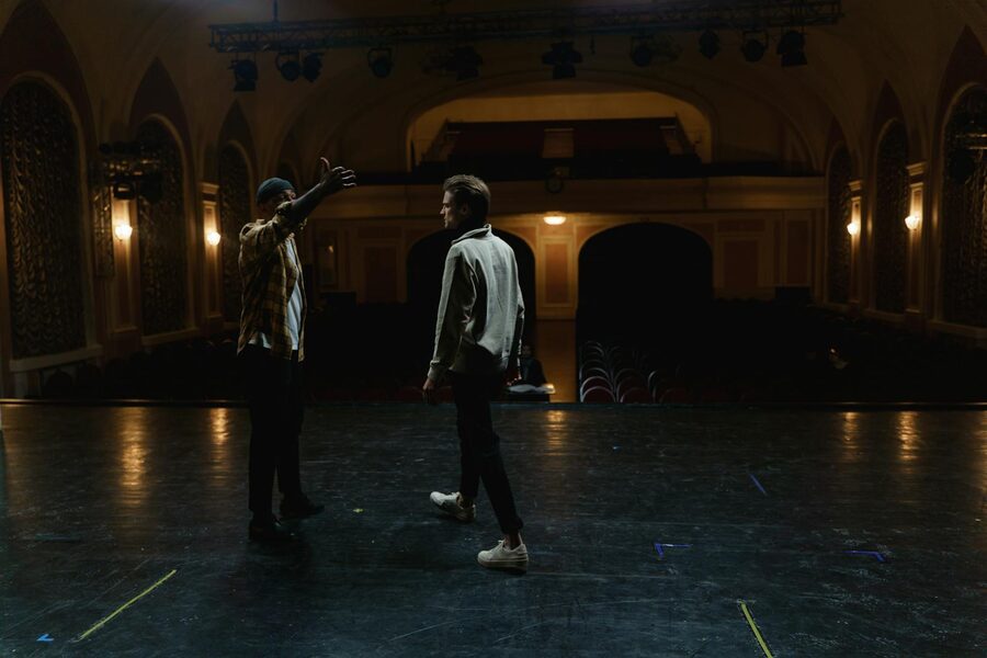 Two performers rehearsing a dramatic scene on stage