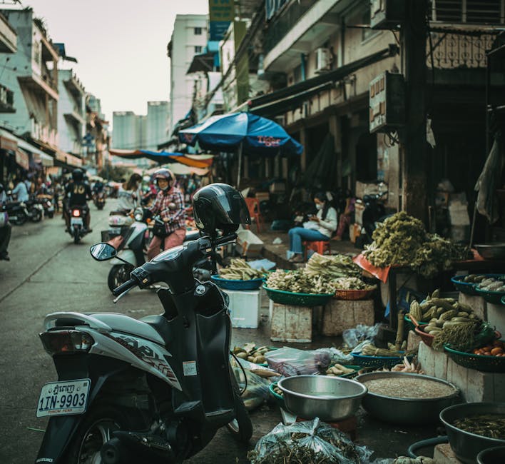 Busy Cambodian street market with motorcycles and produce