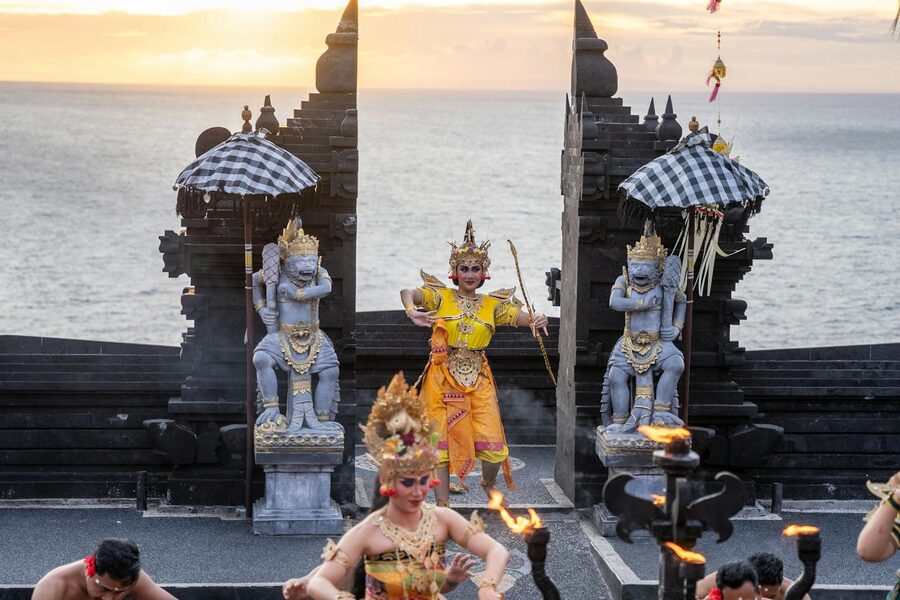 Cultural Balinese dance performance with ocean backdrop at sunset