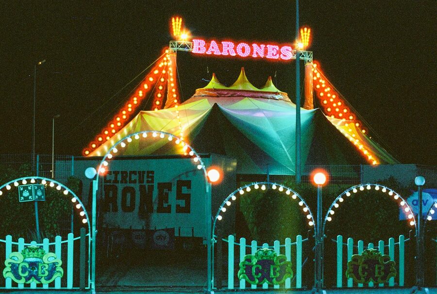 Circus tent lit up at night with neon lights