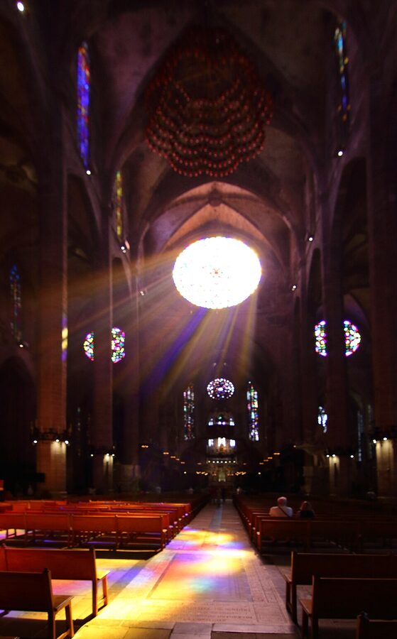 Palma Cathedral rose window over the central nave with stained-glass colours falling