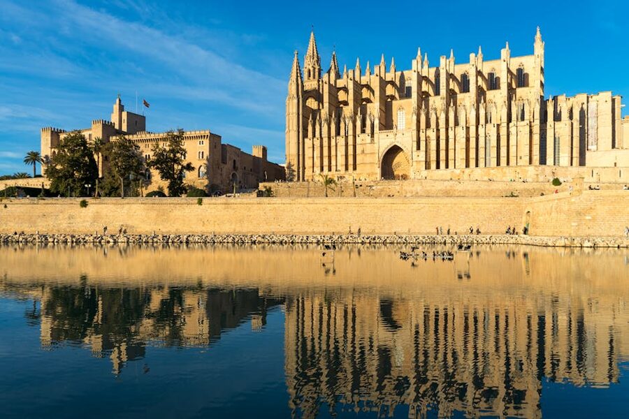 Palma Cathedral reflecting in water under blue sky