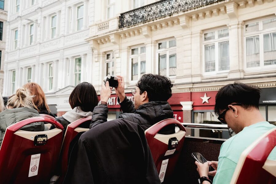 Tourists from behind on an open-top bus exploring city streets