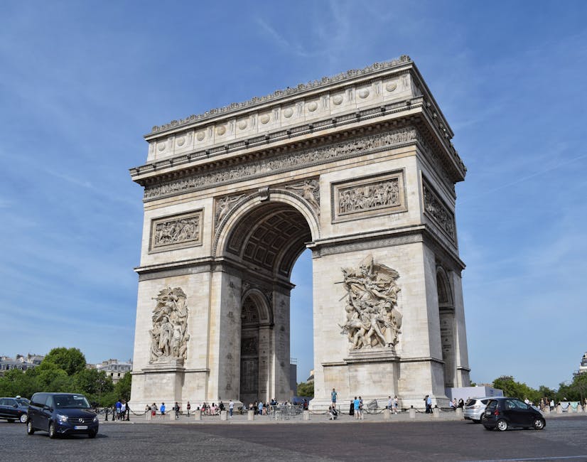 People at the Arc de Triomphe with cars passing in Paris