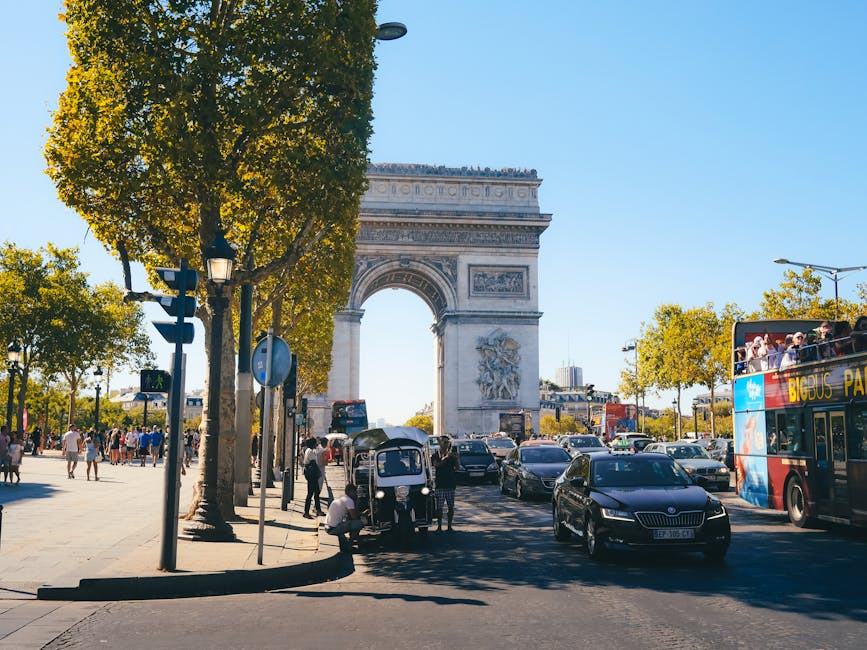 Tourists at the Arc de Triomphe in Paris with traffic