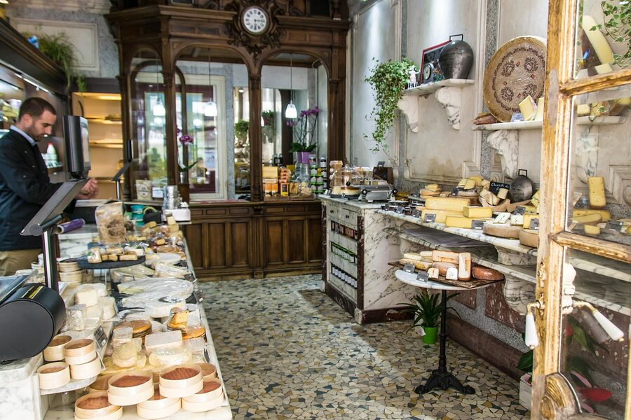 Paris cheese shop with stacked wheels of comte and brie