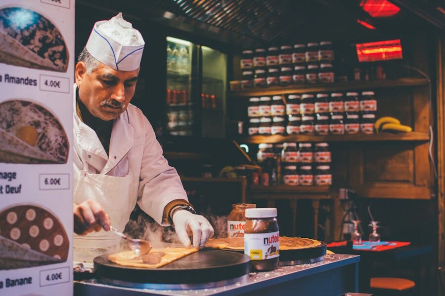 Chef preparing Nutella crepe in cosy Parisian cafe