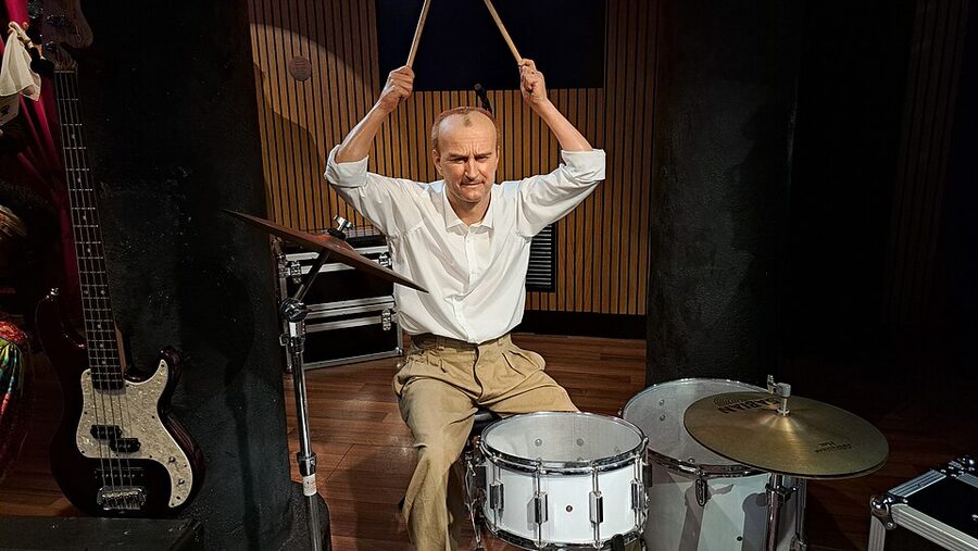 Wax drummer figure in white shirt at drumkit Musee Grevin Paris music zone