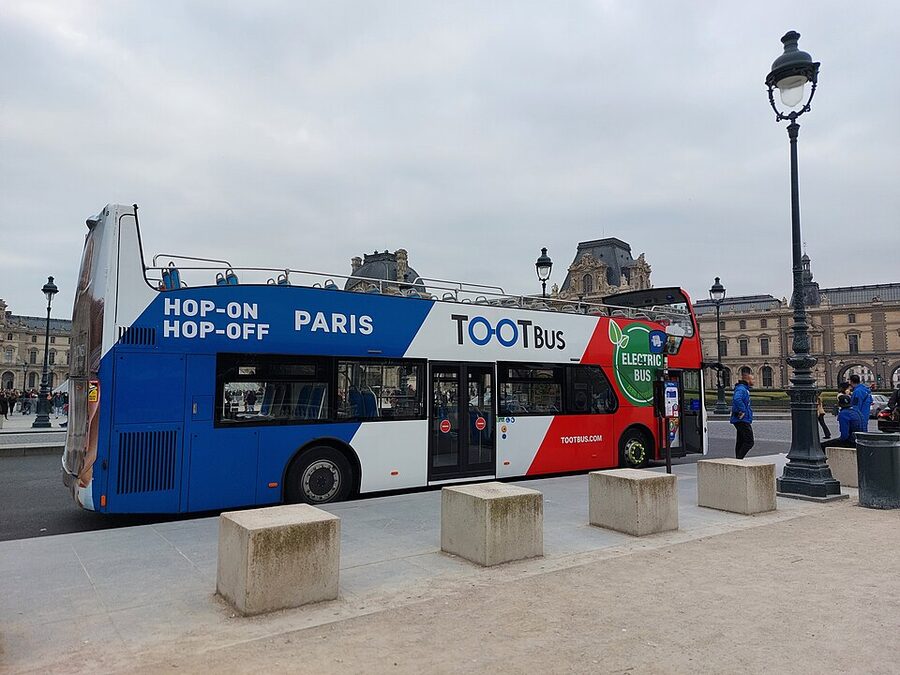 Tootbus Paris electric hop-on hop-off bus stopped at the Louvre Museum
