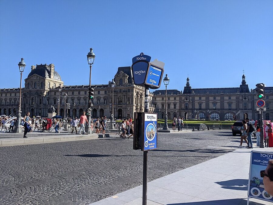 Tootbus Paris stop sign in front of the Louvre Museum