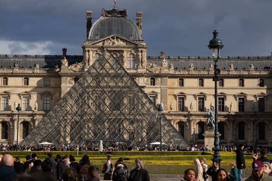 Crowd of visitors in the courtyard of the Louvre Pyramid Paris