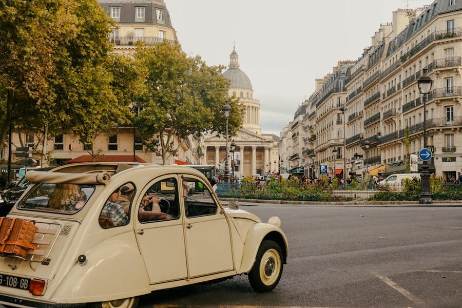 Vintage car parked on street with Pantheon Paris in background