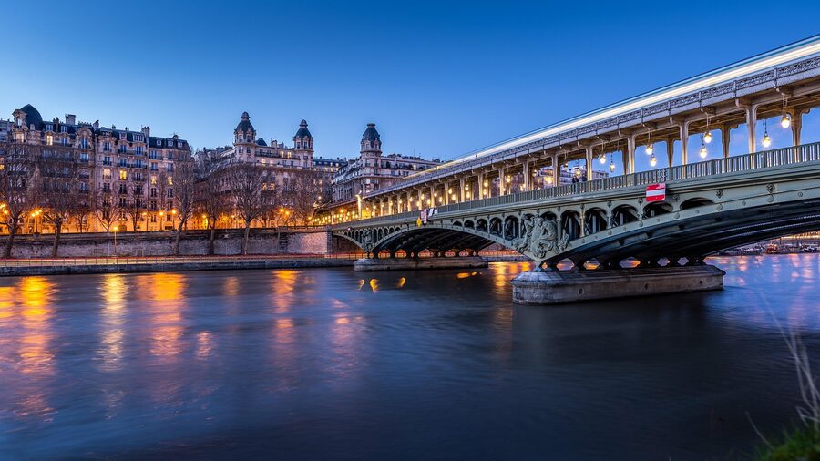 Paris Seine River and bridge with metro lights reflected at night