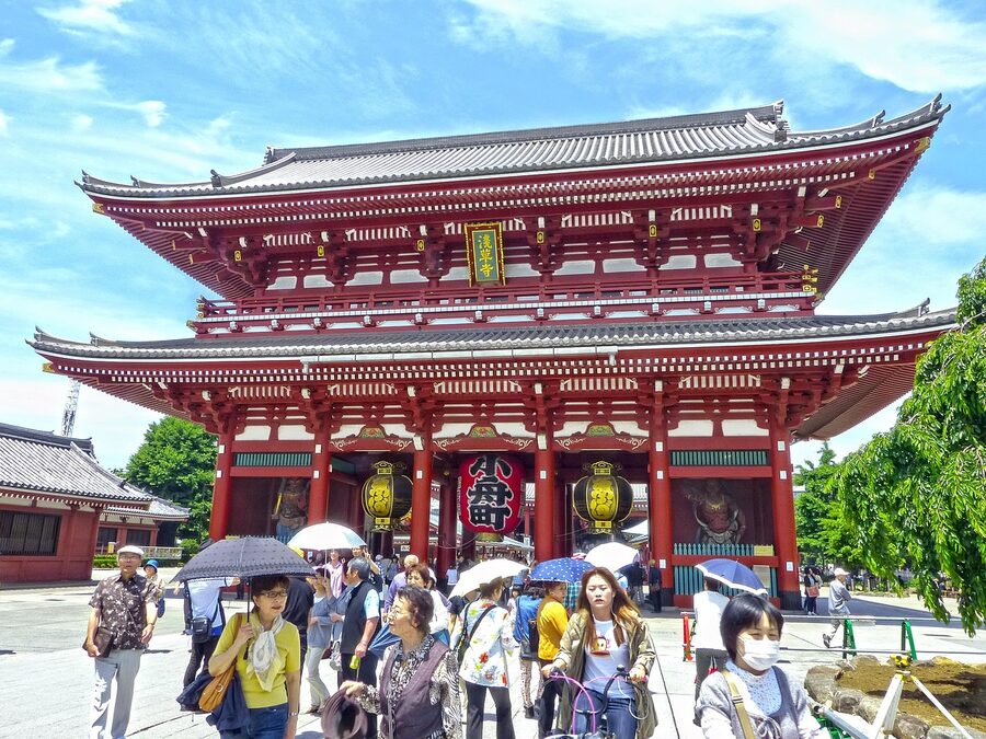 Tourists exploring the traditional Asakusa temple area in Tokyo with pagoda architecture