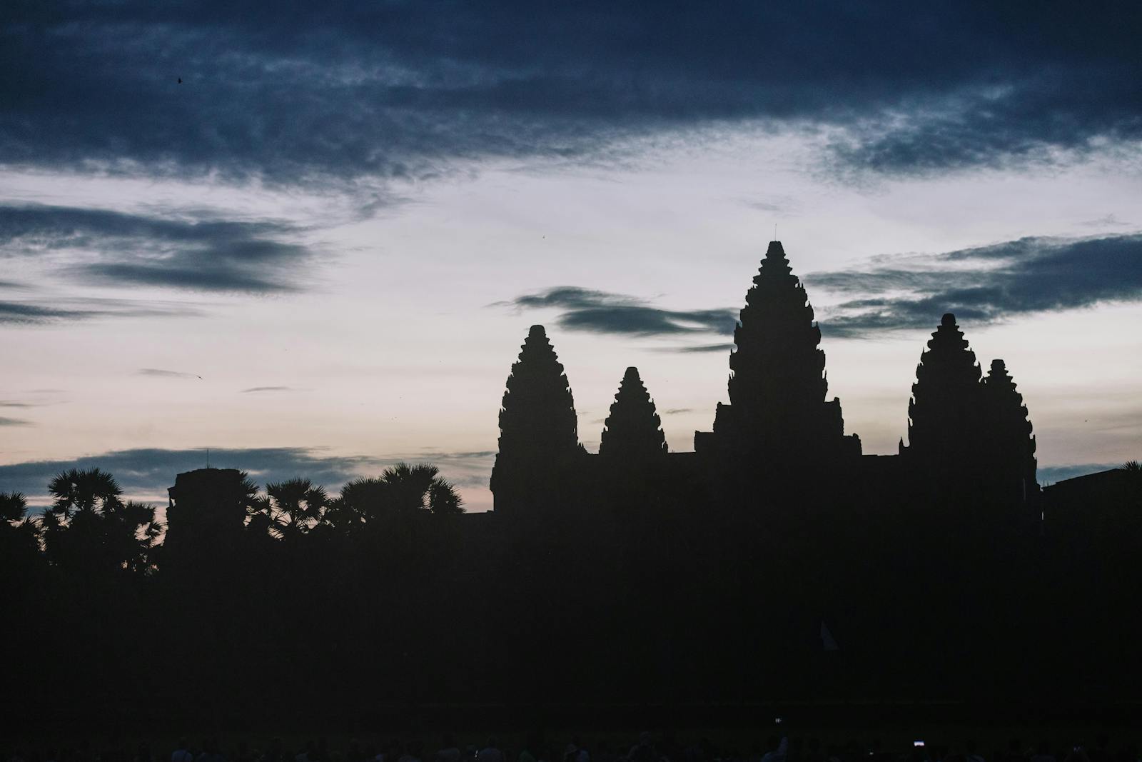 Silhouette of Angkor Wat temple at dusk with dramatic sky
