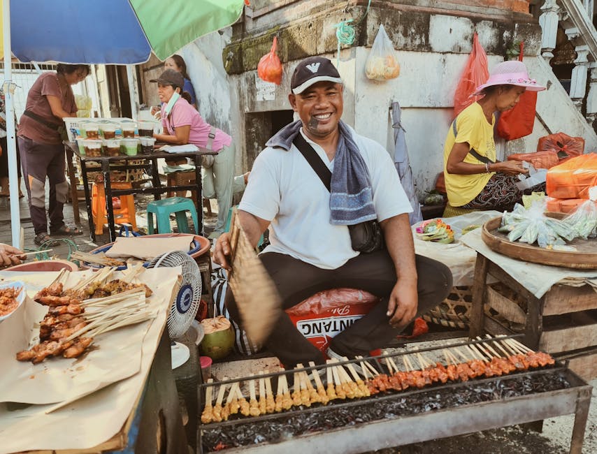 Street vendor grilling satay skewers at a Bali market