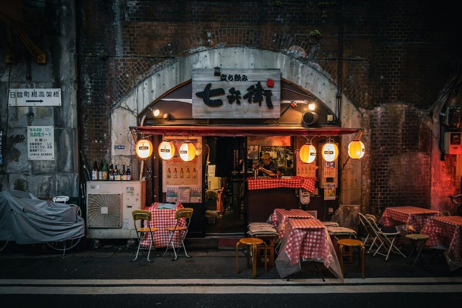 Narrow Tokyo street with izakaya restaurants and warm lantern glow