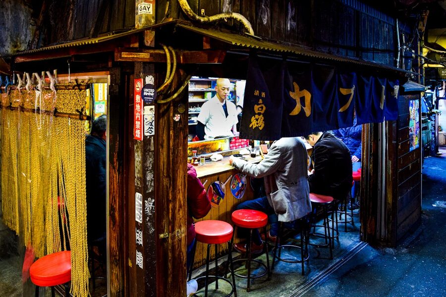 Diners seated at small outdoor counters in Omoide Yokocho, Shinjuku