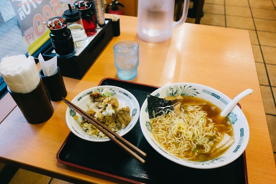 Close-up of a steaming ramen bowl with sliced pork, egg, and nori
