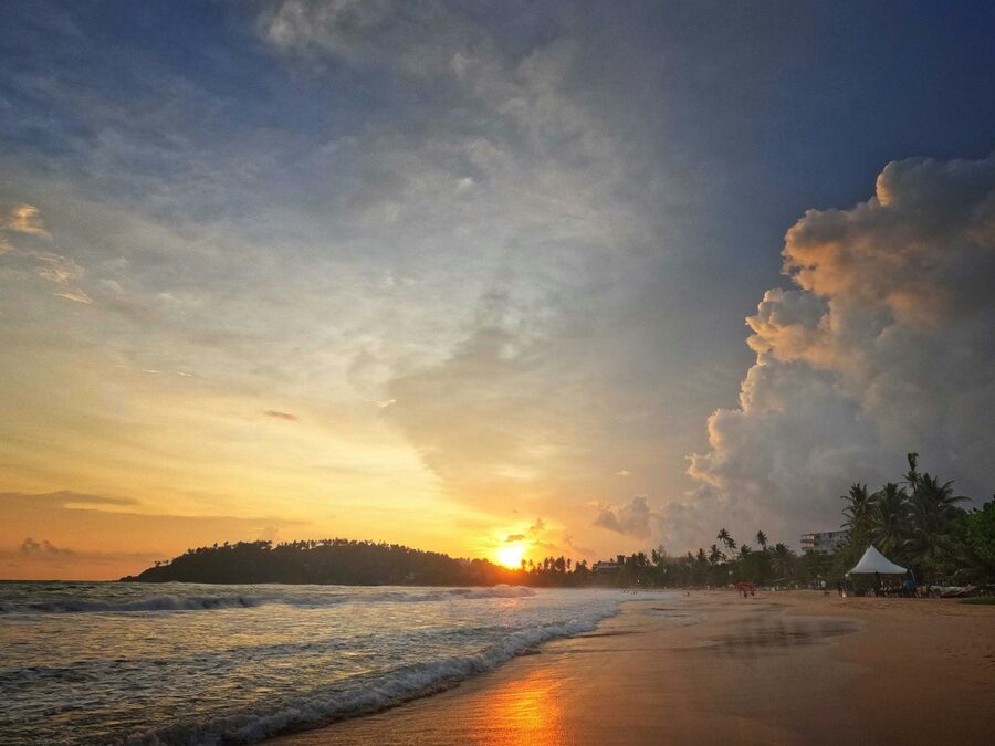 A lively sunset over Mirissa Beach Sri Lanka with calm ocean waters
