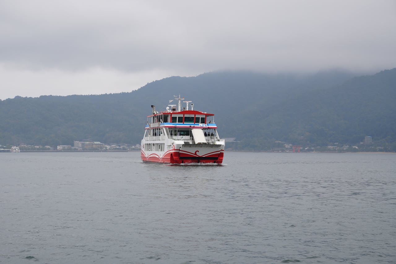 A ferry cruises through Hiroshima Bay with Miyajima Island visible in the background