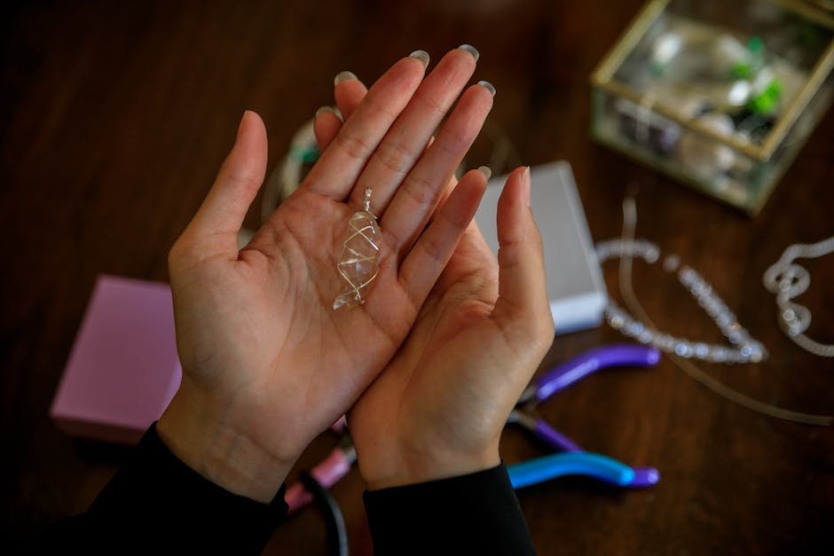 Close-up of hands presenting a handmade silver wire pendant