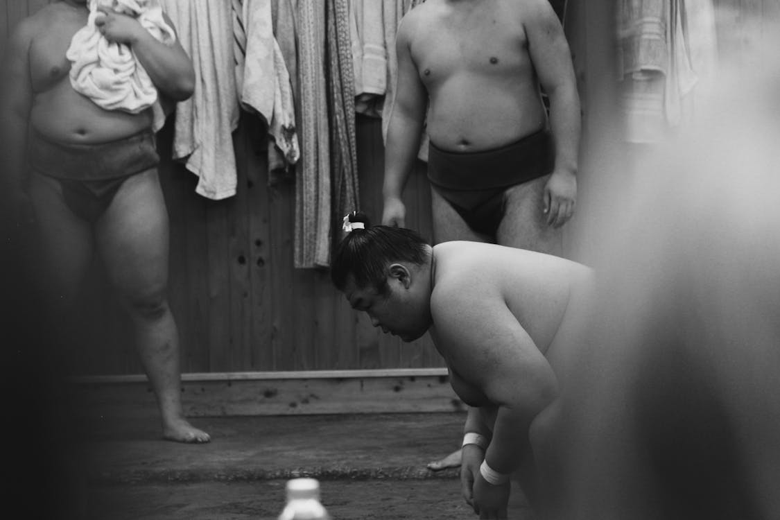 Black and white image of sumo wrestlers in Tokyo showcasing preparation rituals