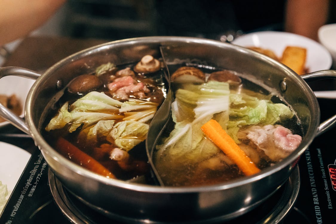 Steaming hot pot filled with meat and vegetables