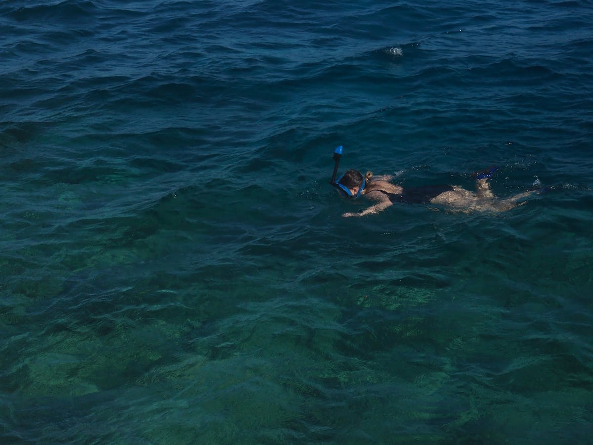 Woman enjoying snorkeling in calm blue ocean water
