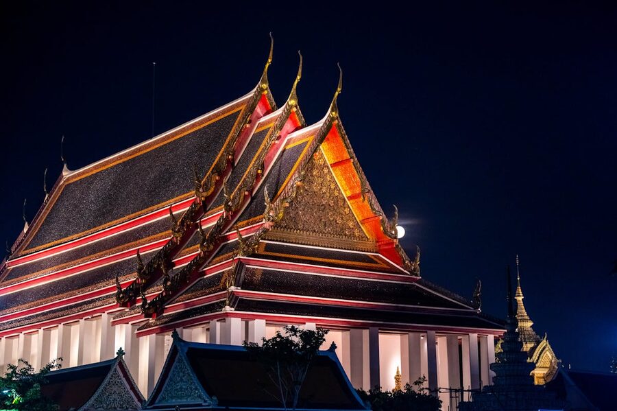 Traditional Thai temple roof lit up at night in Bangkok