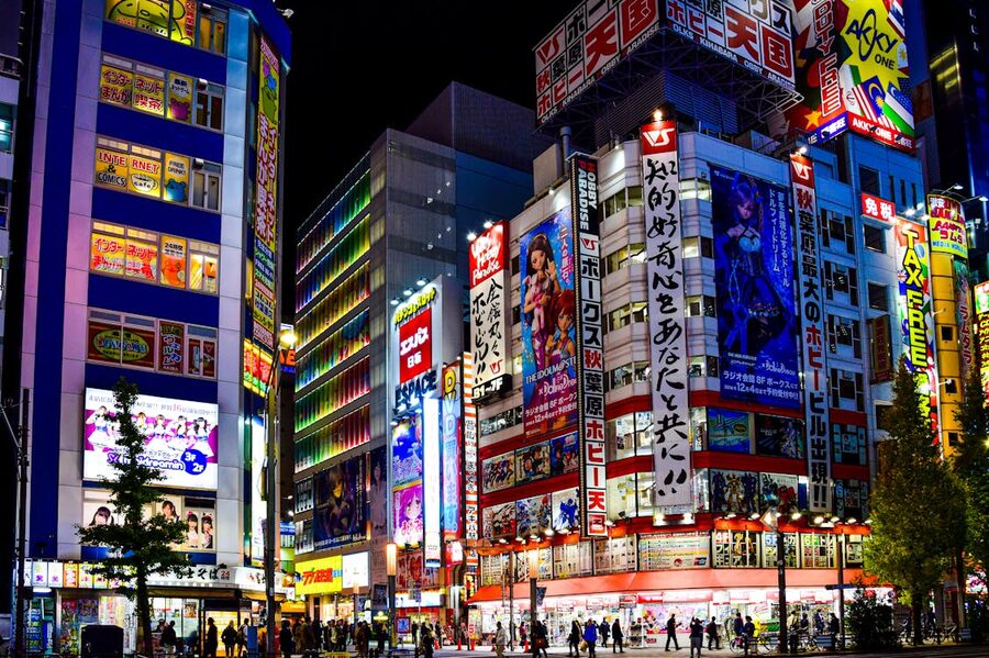 Akihabara district in Tokyo with bright billboards and illuminated streets at night