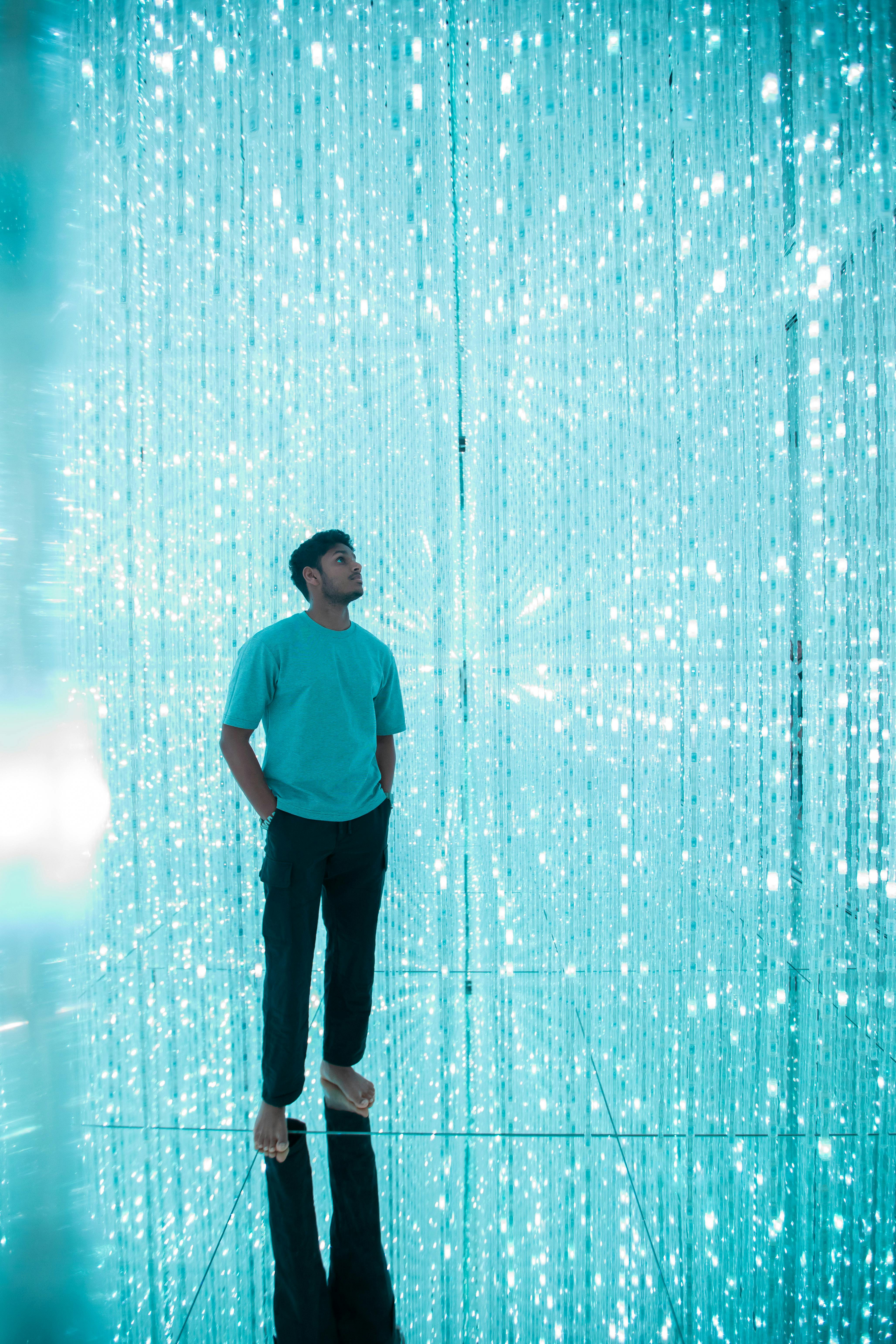 Person standing in a shimmering digital light installation