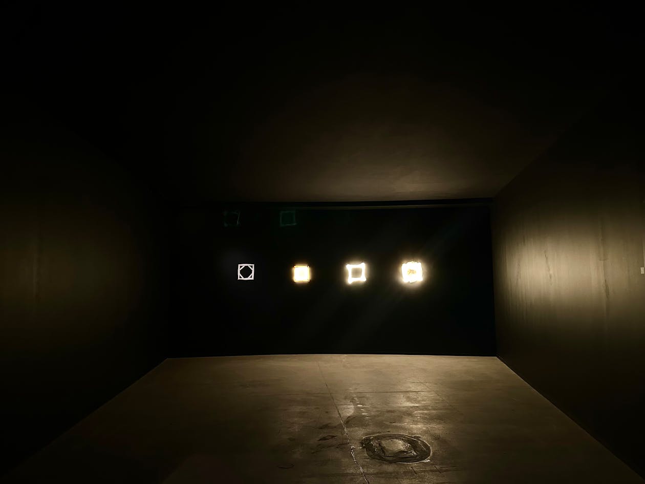 Artistic display of illuminated geometric shapes in a dark room setting
