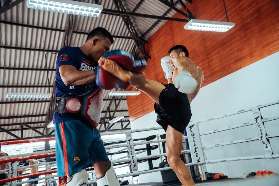 Two fighters in a dynamic Muay Thai training session inside a gym