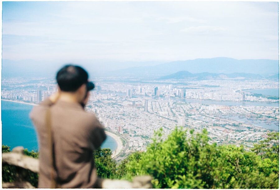 Person photographing the Da Nang cityscape from a mountain observation point