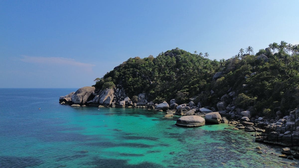 Aerial view of Shark Bay Koh Tao with turquoise water and green hills