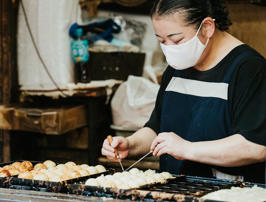Takoyaki being prepared at an outdoor stall in Osaka