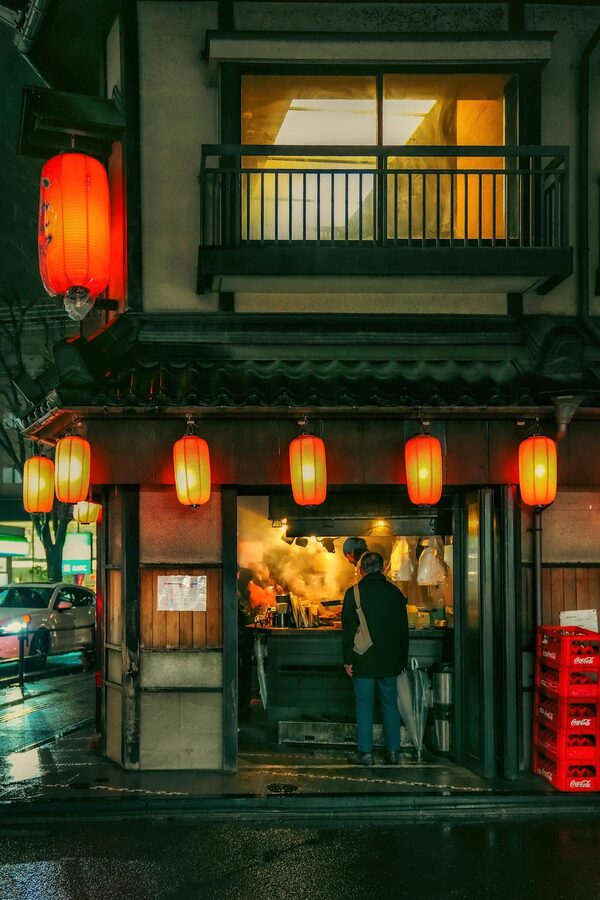 Japanese izakaya entrance with traditional lanterns and wooden decor