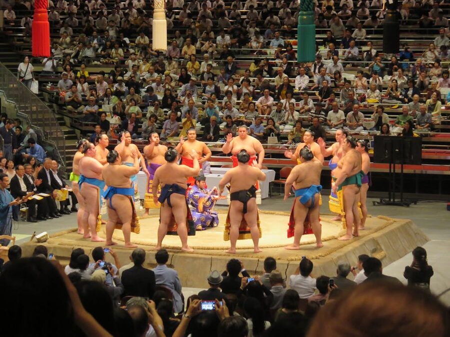 Group of sumo wrestlers gathered in a Tokyo arena during a traditional tournament