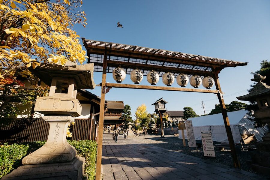 Traditional Japanese temple gate with stone lanterns