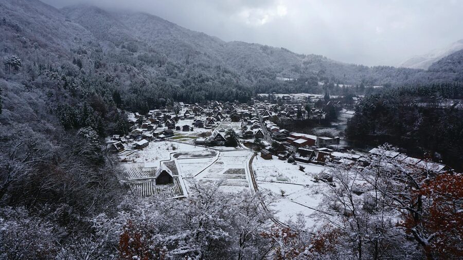 Aerial view of snow-covered Shirakawa-go village set between mountains in winter