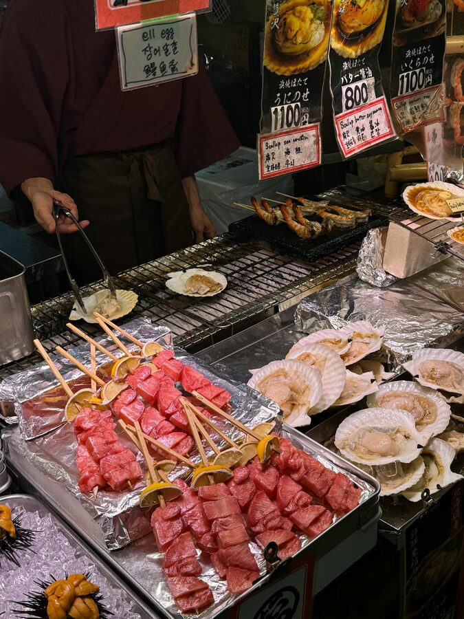 Street food stalls in Osaka with colorful signage and fresh seafood on display