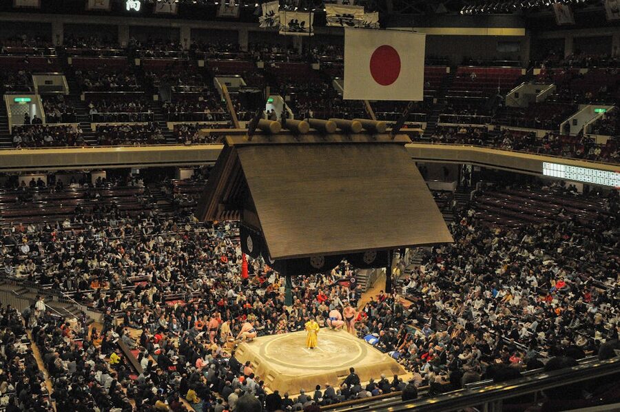 Large crowd watches a traditional sumo wrestling match inside a Japanese arena