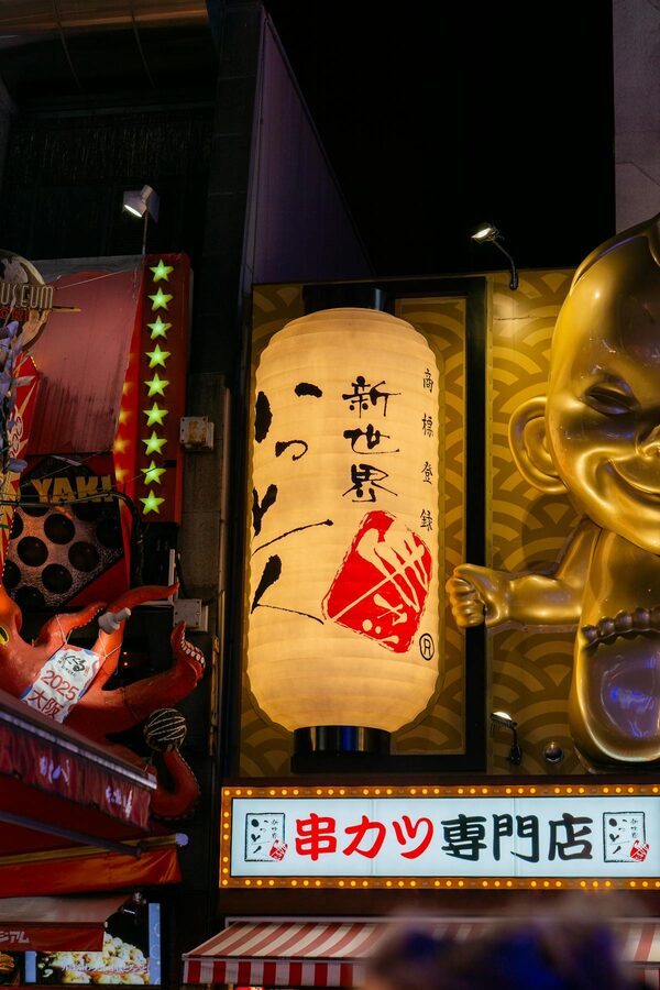 Colorful neon signs and lanterns along Dotonbori canal in Osaka at night