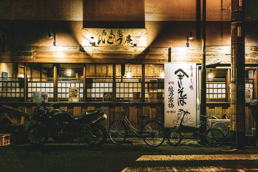 Night street scene in Osaka food district with warm lantern lighting